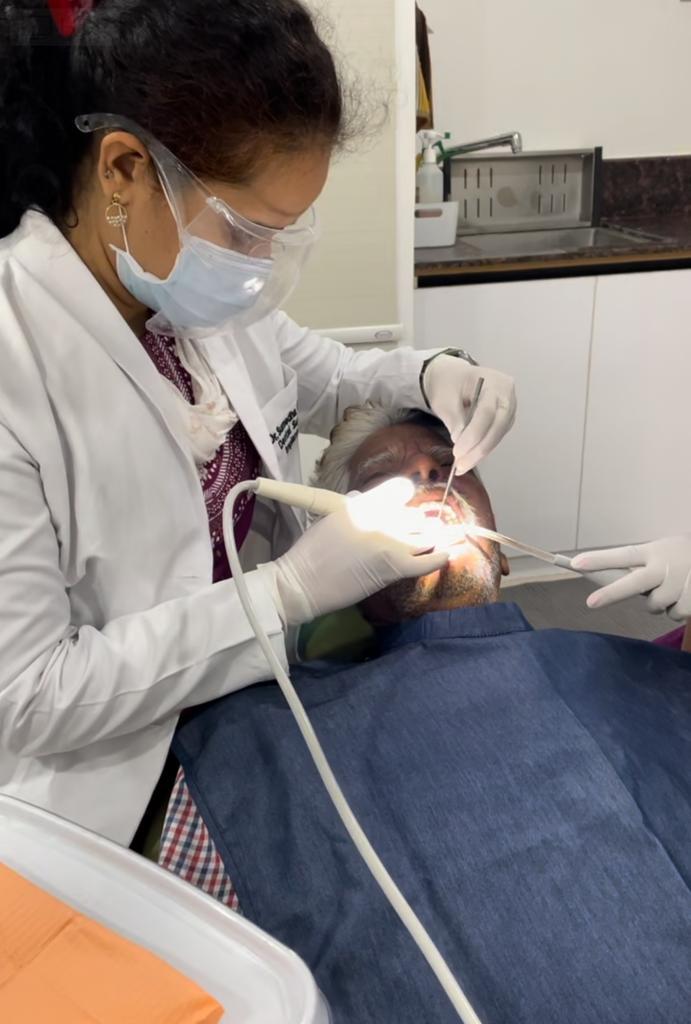 Dr. Sumedha performing dental procedure on elderly patient at Sharanya Dental Clinic in Kondapur