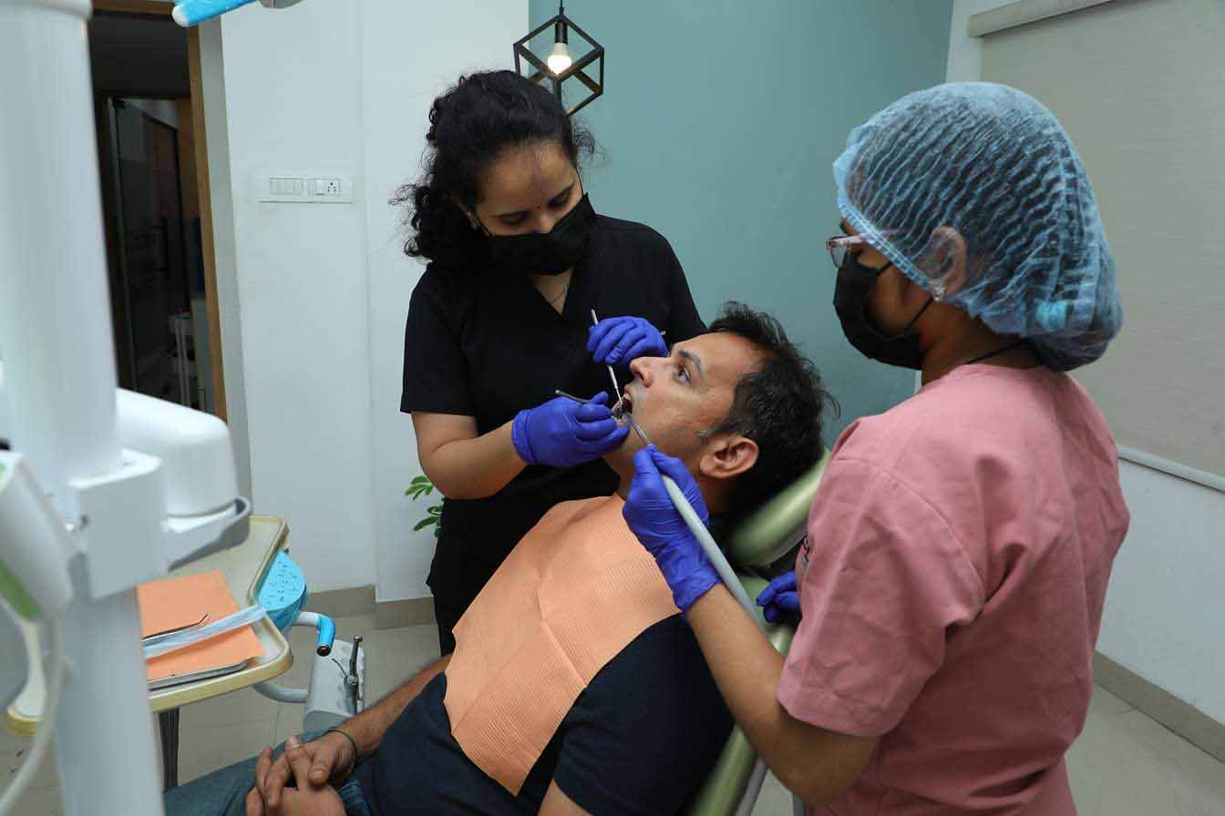 Dr. Sumedha performing a dental procedure on a male patient at Sharanya Dental Clinic, Kondapur